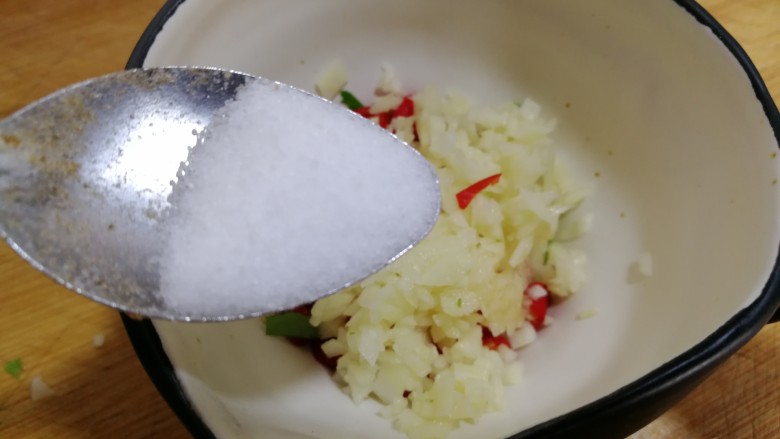 凉拌千张,将小米辣蒜末放到调料碗内，放半小勺盐。