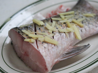 清蒸草鱼（紫苏味）,在鱼尾两面分别划两刀方便熟和入味，姜切丝铺上；