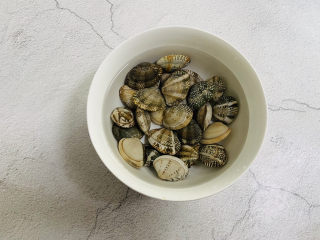 丝瓜花蛤汤,花蛤清洗干净放入碗中加入清水、适量盐浸泡60分钟，让其张口吐沙