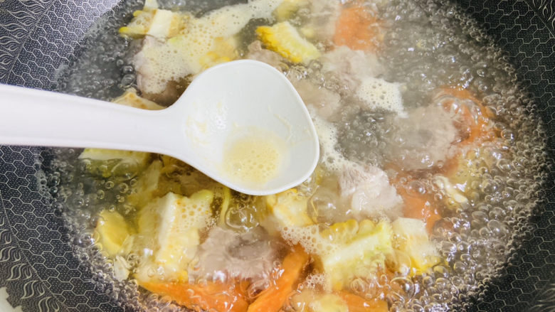 胡萝卜玉米排骨汤,撇去浮沫，转中火煮至排骨熟烂