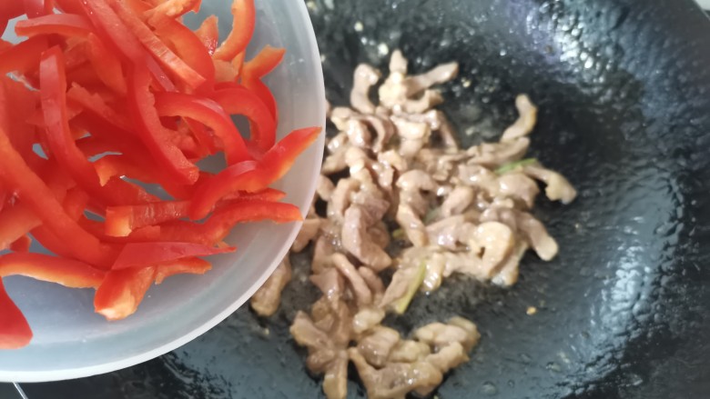 白玉菇炒肉,肉炒至八分熟，倒入红椒丝翻炒片刻