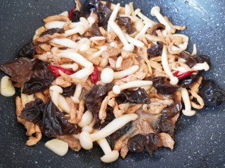 白玉菇炒肉,下入炒好的肉丝翻炒均匀。