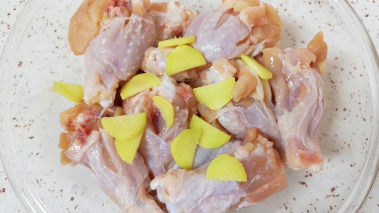 香辣鸡翅根,将处理好的鸡翅根放入盆里，放入生姜片搅拌均匀。