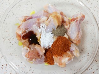 香辣鸡翅根,放入盐、糖粉、黑胡椒粉、辣椒粉、生抽和蚝油。