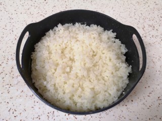 芝士焗饭,时间到米饭已经蒸好了，将滤糖甑从电饭煲里面取出，用铲子翻动米饭散一下热气。