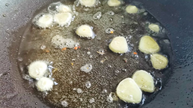 黄瓜炒香肠,锅中热油爆香大蒜。