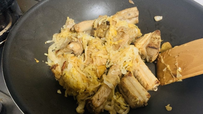 酸菜炖排骨,排骨上色后将酸菜放入锅中翻炒