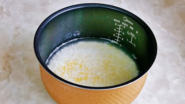 小米蒸排骨,泡好后倒入电饭煲中，水量可以根据个人平时的习惯来加。