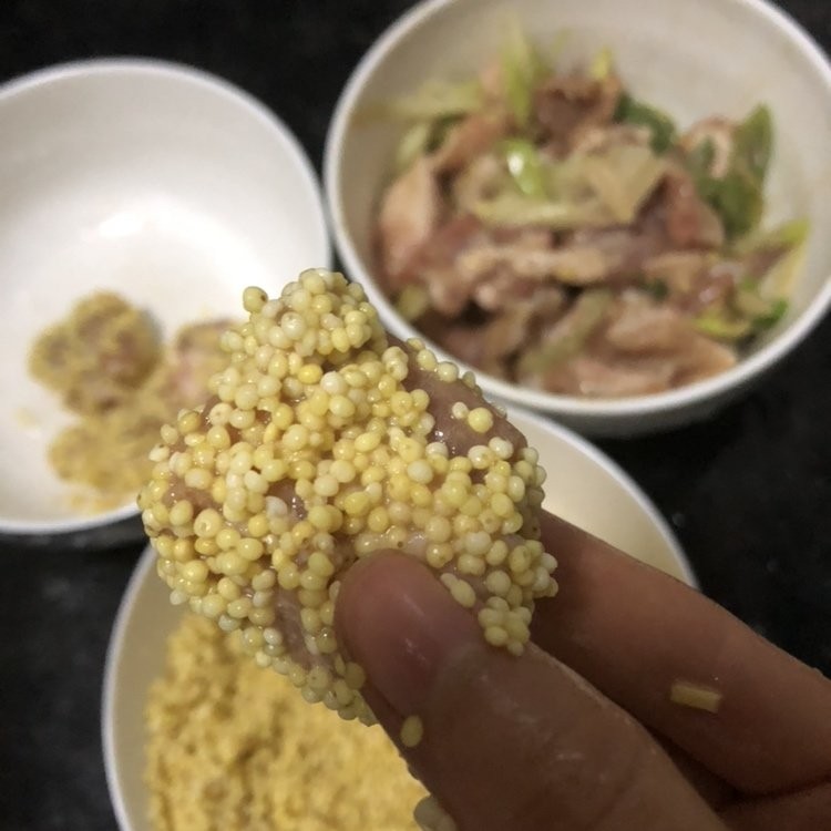 小米蒸排骨,泡好的小米沥干水分，将腌制好的排骨均匀裹上小米