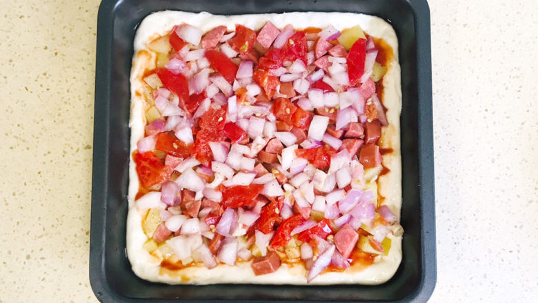 培根火腿披萨,将西红柿丁和洋葱丁平铺好，用手压平