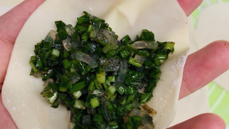韭菜粉丝蒸饺,取个皮放入馅料。