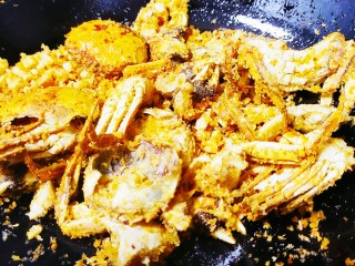 避风塘螃蟹,倒入炸好的螃蟹，小火翻炒，加入盐和白砂糖，小火慢炒