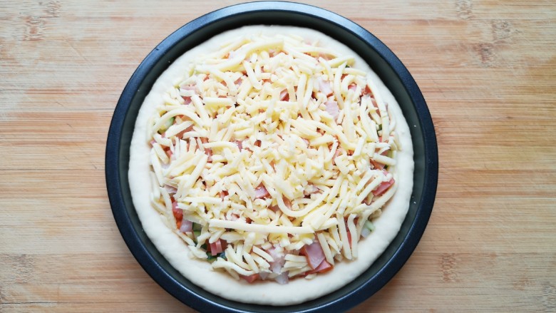 培根火腿披萨,最后再撒上一层马苏里拉芝士，以同样的方法做好另一个披萨。