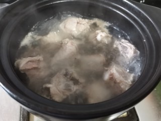 酸菜炖排骨,煮开后用勺子撇去表面的浮沫。
