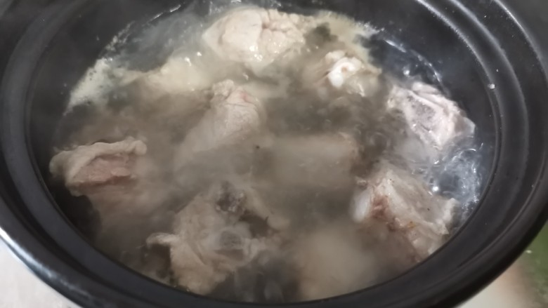 酸菜炖排骨,煮开后用勺子撇去表面的浮沫。