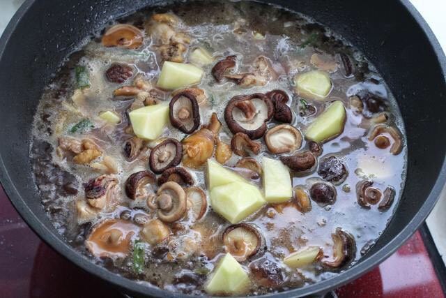 香菇焖鸡,把香菇和土豆块一同放入锅中，改中小火炖煮约二十分钟。