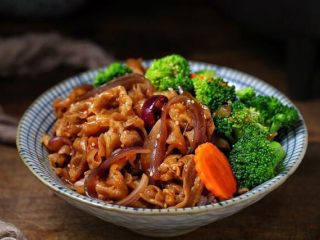 日式肥牛饭,将米饭盛入碗中，摆上西兰花和胡萝卜，上面铺肥牛再淋适量的汤汁。