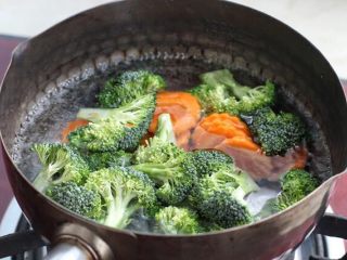 日式肥牛饭,锅中烧开水淋入少许食用油和一茶匙盐，放入西兰花和胡萝卜焯烫一、两分钟捞出备用。