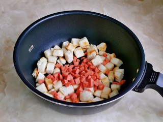 烤馒头片,馒头烤至微黄时加入切好的肠丁，翻炒2分钟。