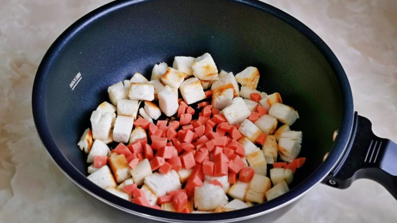 烤馒头片,馒头烤至微黄时加入切好的肠丁，翻炒2分钟。