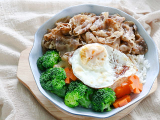 日式肥牛饭,最后摆上煮熟的西蓝花，胡萝卜，翻炒好的洋葱肥牛卷，再煎一个荷包蛋，美味的日式肥牛饭就做好了。