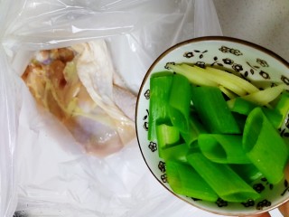 新奥尔良烤鸡腿,葱段和2片姜切碎，连同鸡腿放进保鲜袋里。