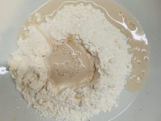 八寸花边披萨饼胚,把酵母水搅拌均匀倒入面粉里。