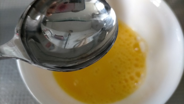 香肠炒蛋,磕入碗中搅拌至起泡，加一勺水，目的是炒的时候不会炒老，出锅口感丝滑细腻