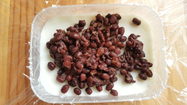 山药红豆糕,上面放上一层红豆，用勺子铺均匀。