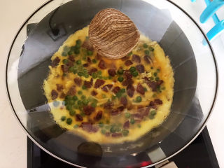 香肠炒蛋,鸡蛋液底部凝固后盖上锅盖，焖2分钟