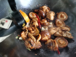 香菇焖鸡,再倒入生抽和老抽翻炒，然后加入适量的热水。