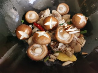 香菇焖鸡,加入香菇翻炒。