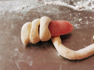 香肠馒头卷,取一条盐水香肠 将面条缠绕在香肠上