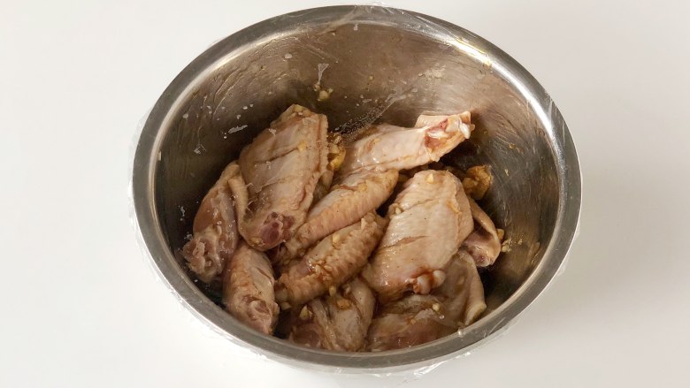 网红薯片鸡翅，不加一滴油也能外脆里嫩又多汁,把鸡翅盖上保鲜膜，放入冰箱冷藏60分钟以上，如果时间允许可以隔上一夜，鸡翅会更入味。
