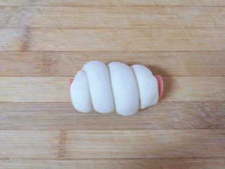 香肠馒头卷,取半根火腿肠，将卷好的长条状面团缠绕在火腿肠上面，一个香肠馒头卷就做好了，依次做完剩下的馒头卷。