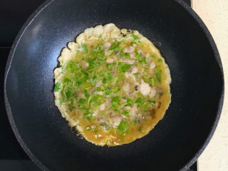 蚵仔煎,不要搅拌，转中火，煎至结实，晃动一下锅体，海蛎子鸡蛋饼可以顺利地离开锅体，就是煎结实了