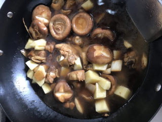 香菇焖鸡,加入土豆和适量清水翻炒均匀盖上锅盖焖煮15分钟