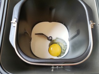 黄油面包卷,面包机桶内加入牛奶，打入一个鸡蛋。