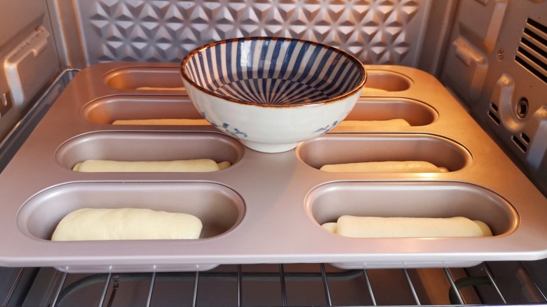 黄油面包卷,烤箱调至“发酵”功能，将面包放入烤箱内，放一碗热水，40度发酵40分钟。