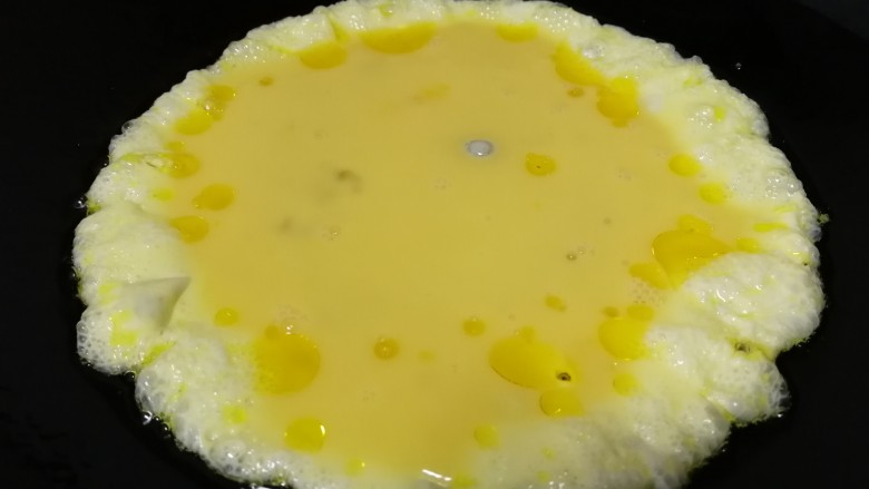 秋葵炒鸡蛋,油5成热倒入蛋液，文火把蛋液摊熟。