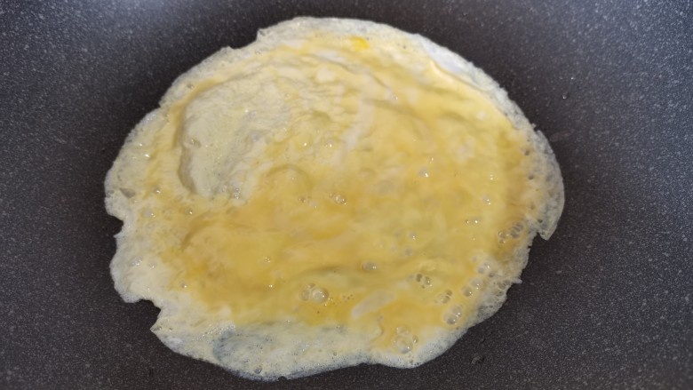 香肠炒蛋,转动锅，摊成一张鸡蛋饼，然后再用剩下的蛋液再摊一个鸡蛋饼待用。