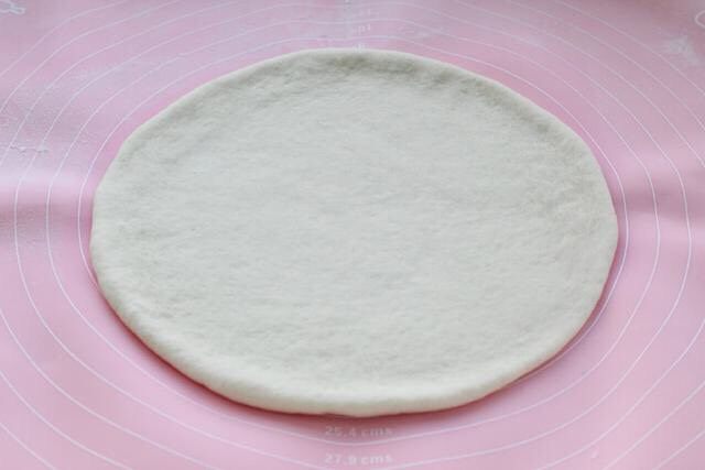 芝士榴莲披萨,取出面团排气后用擀面杖擀成圆形的饼皮，直径大约22厘米，相当于一个九寸大的披萨。