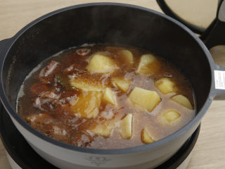 土豆牛肉,大火煮开后，小火炖煮40分钟，直到筷子能顺利插入牛腩，捞出生姜、桂皮、八角、大葱、香叶。