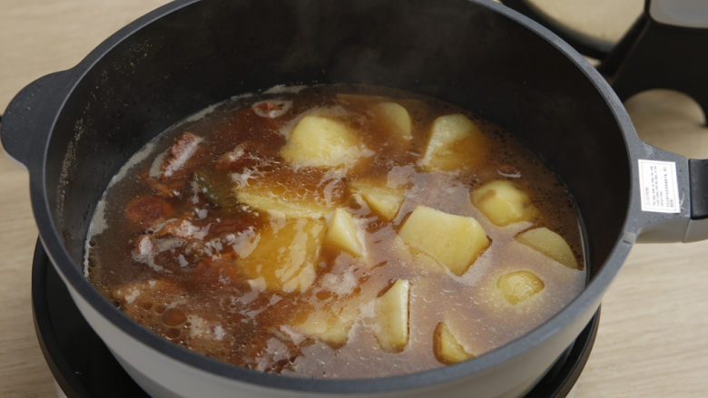 土豆牛肉,大火煮开后，小火炖煮40分钟，直到筷子能顺利插入牛腩，捞出生姜、桂皮、八角、大葱、香叶。