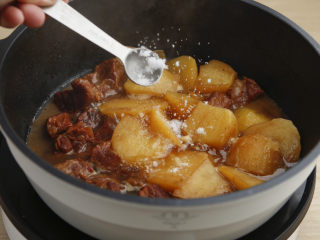 土豆牛肉,将准备好的土豆放入锅中，继续小火炖煮20分钟，期间放入15克，冰糖，1茶匙盐调味，最后汤汁收浓即可。