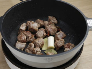 土豆牛肉,然后放入大葱、生姜、八角、桂皮、香叶一起翻炒出香味。
