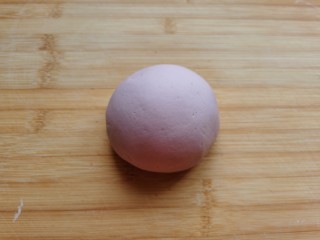 紫薯玫瑰花馒头,将面絮和成面团，放到面板上，反复将面团揉至光滑。