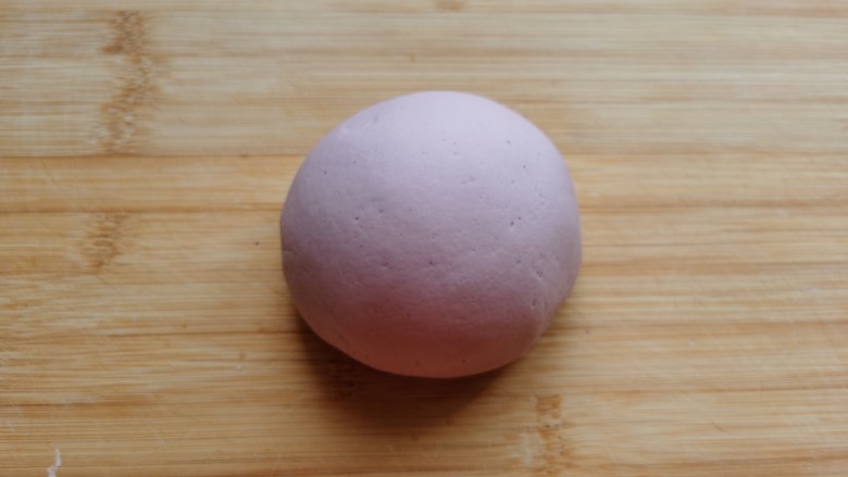 紫薯玫瑰花馒头,将面絮和成面团，放到面板上，反复将面团揉至光滑。