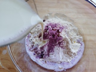 紫薯玫瑰花馒头,倒入牛奶，边倒边搅拌面粉成絮状。牛奶的用量可根据不同面粉的差异适度调整。
