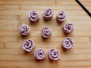 紫薯玫瑰花馒头,双手将玫瑰花底部四周往里收压一下，防止醒发后散开，漂亮的紫薯玫瑰花🌹🌹馒头就做好了。